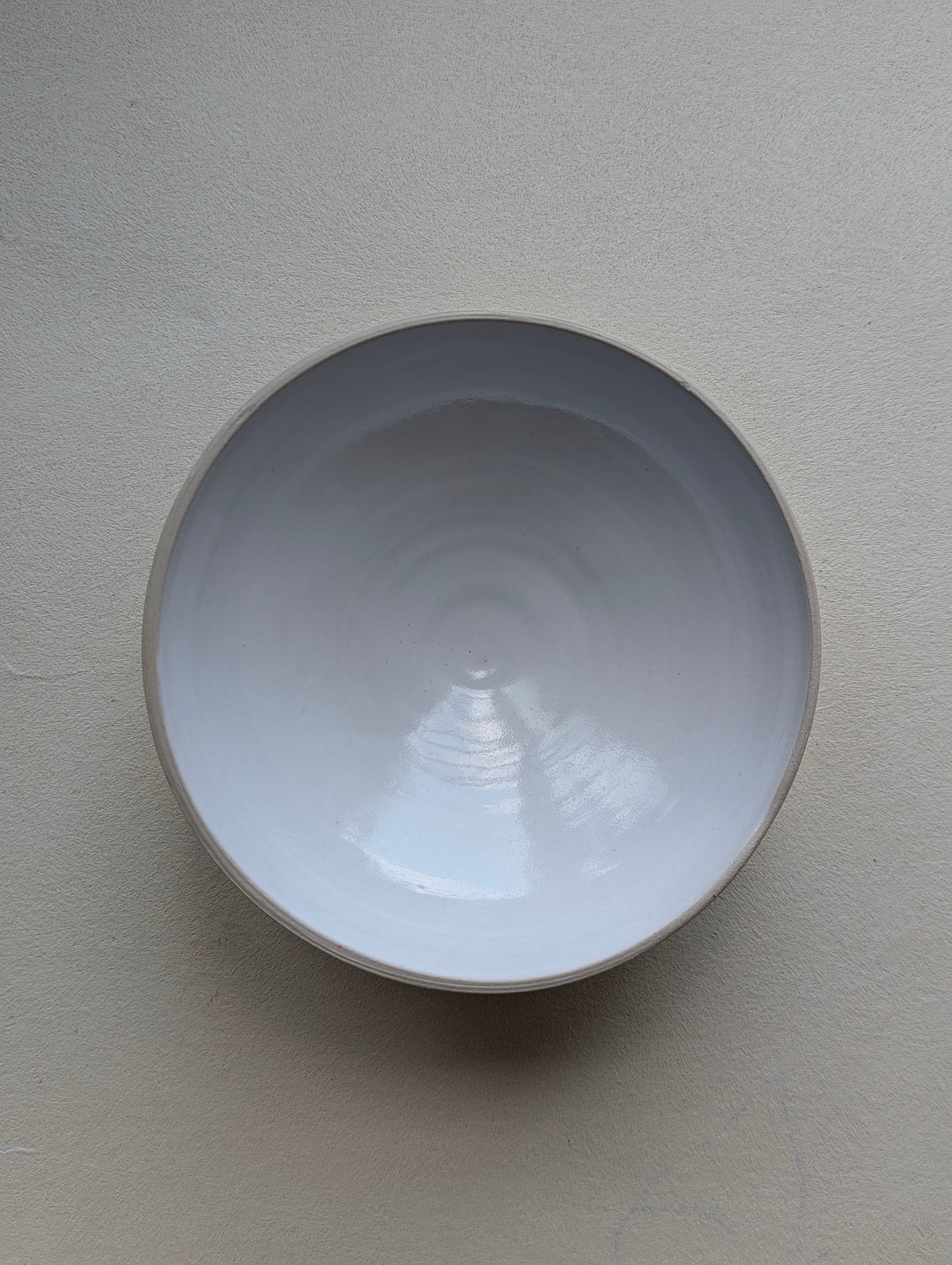 Top view of a handmade stoneware snack bowl, highlighting the glossy white glazed interior.