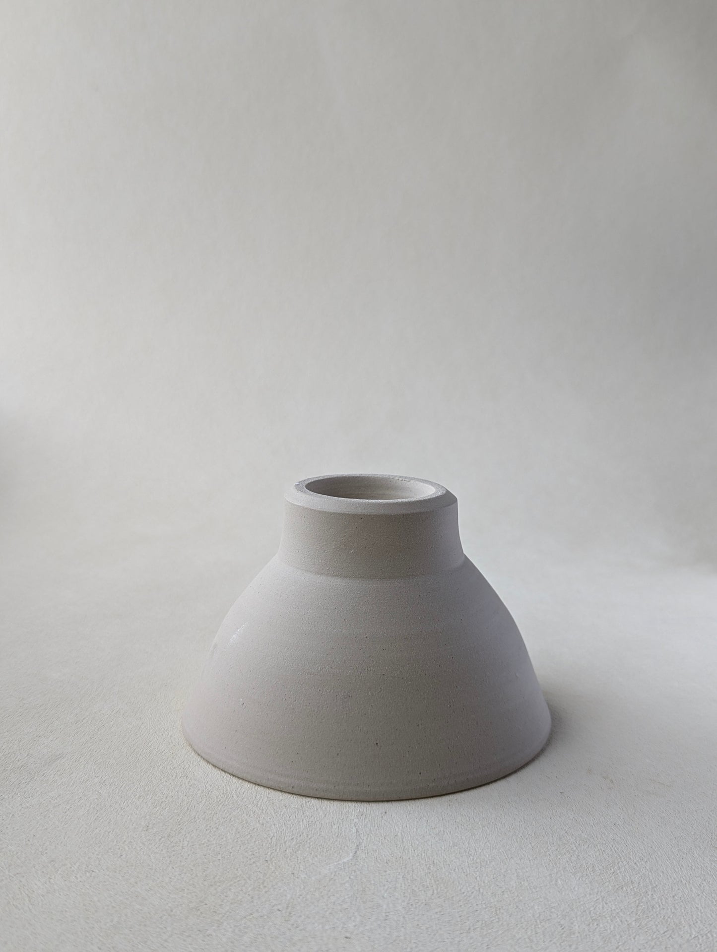 One handmade stoneware snack upside down to demonstrate  the beautiful bottom detailing and raw exterior.