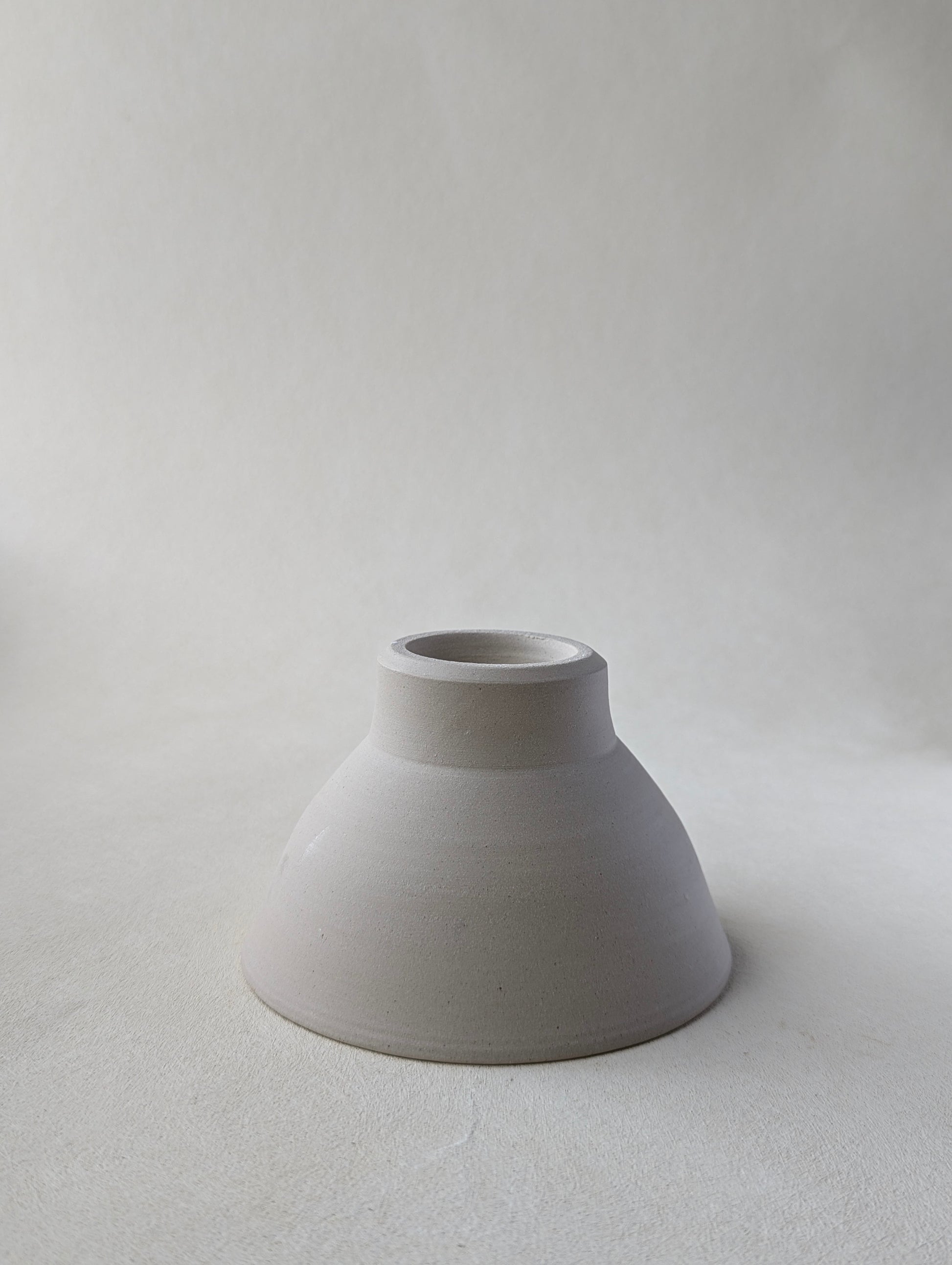 One handmade stoneware snack upside down to demonstrate  the beautiful bottom detailing and raw exterior.
