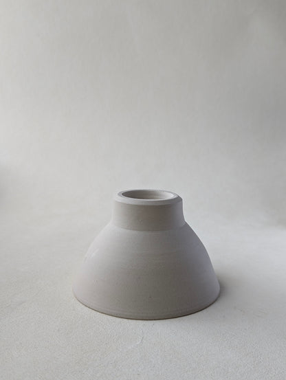 One handmade stoneware snack upside down to demonstrate  the beautiful bottom detailing and raw exterior.