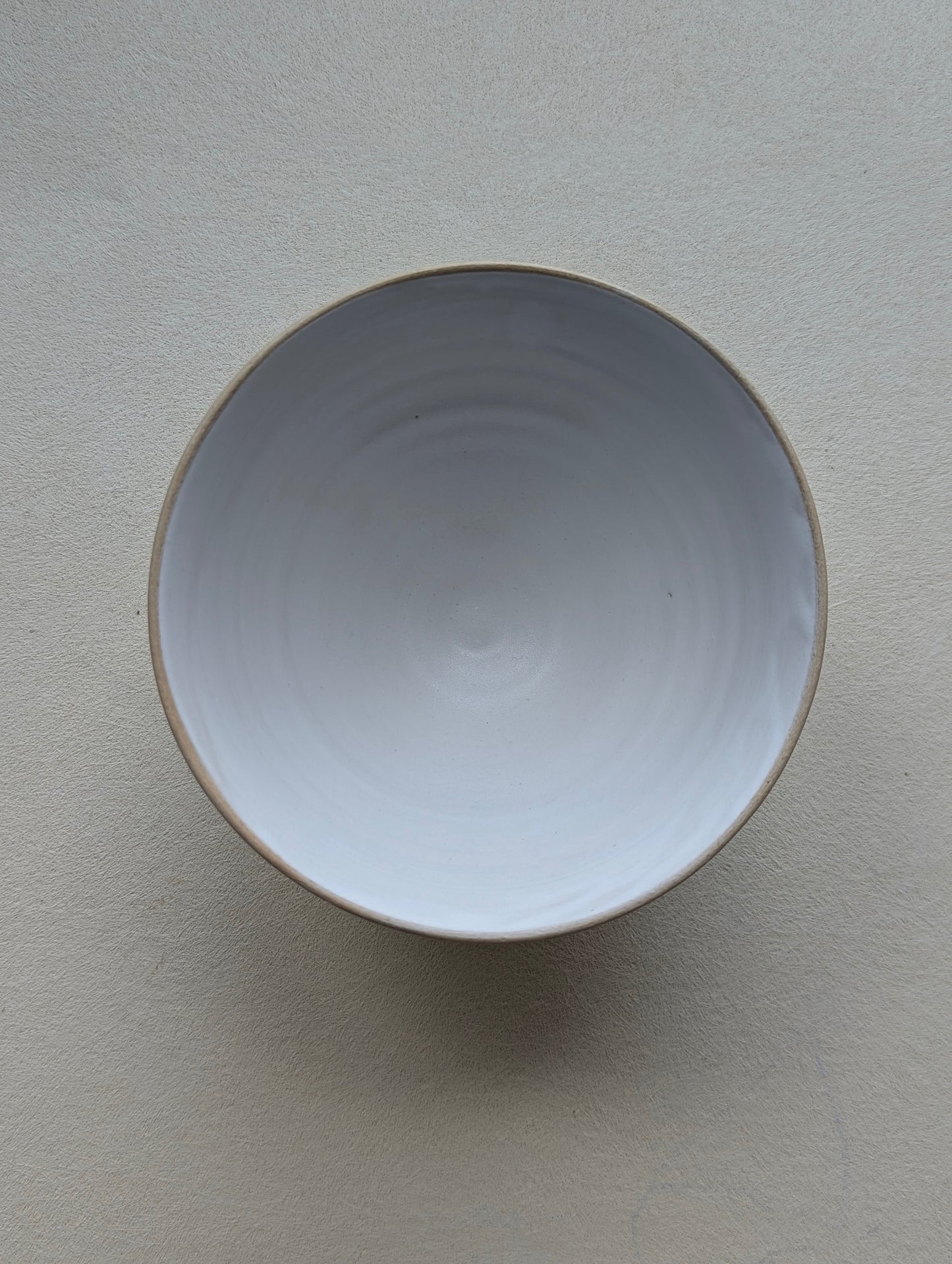 Top view of a handmade stoneware snack bowl, highlighting the matte white glazed interior.