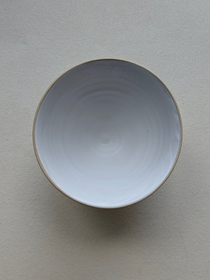 Top view of a handmade stoneware snack bowl, highlighting the matte white glazed interior.